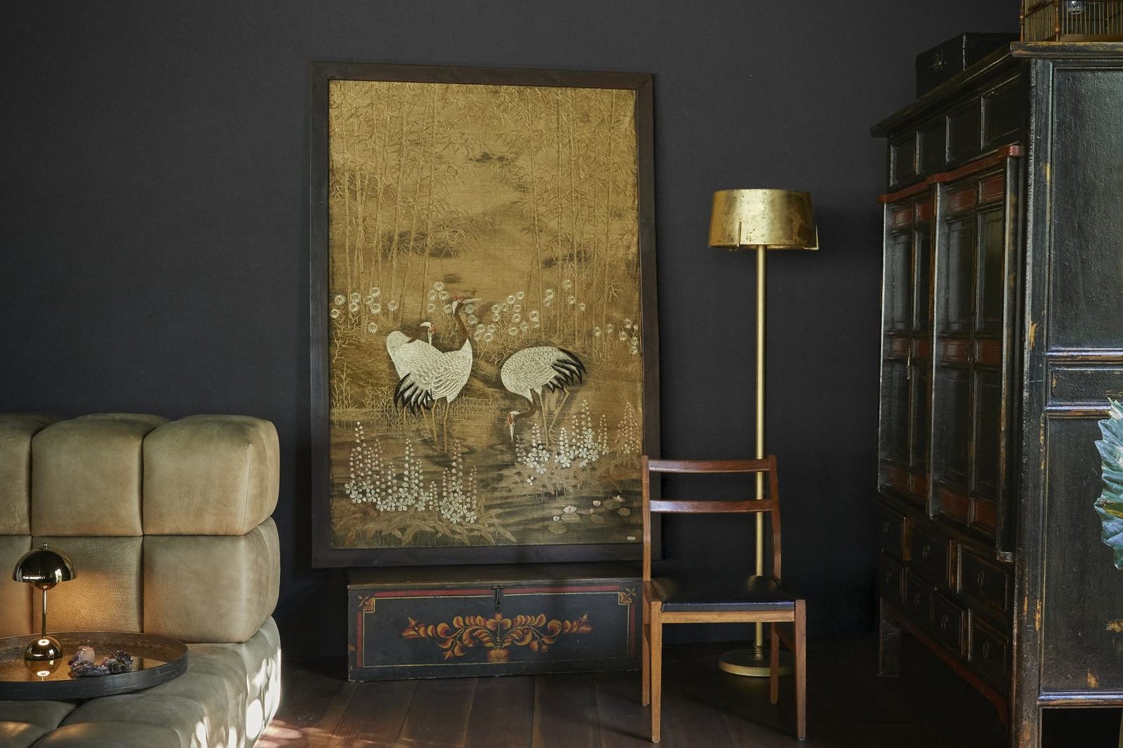 Embroidered crane artwork and brass floor lamp
